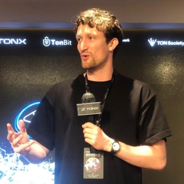 Antoine Moncomble speaking on stage at an event